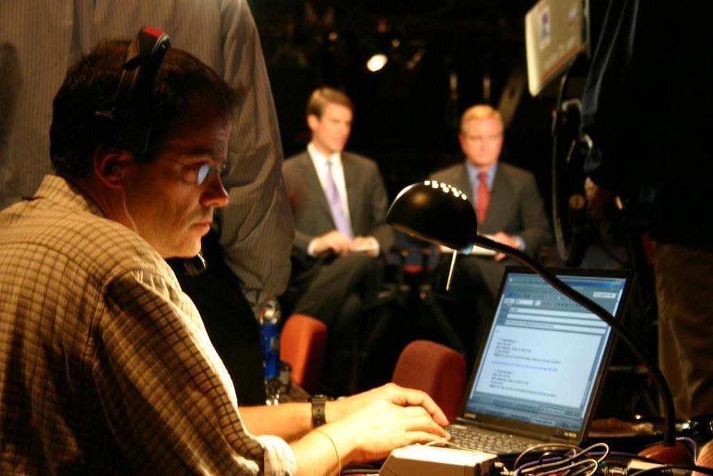 A producer checks e-mail while ABC News anchors wait for the commercial break to end just after the debate ends, inside the audi