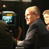 Rudy Giuliani being interviewd on the Fox News stage, Sean Hannity in the background